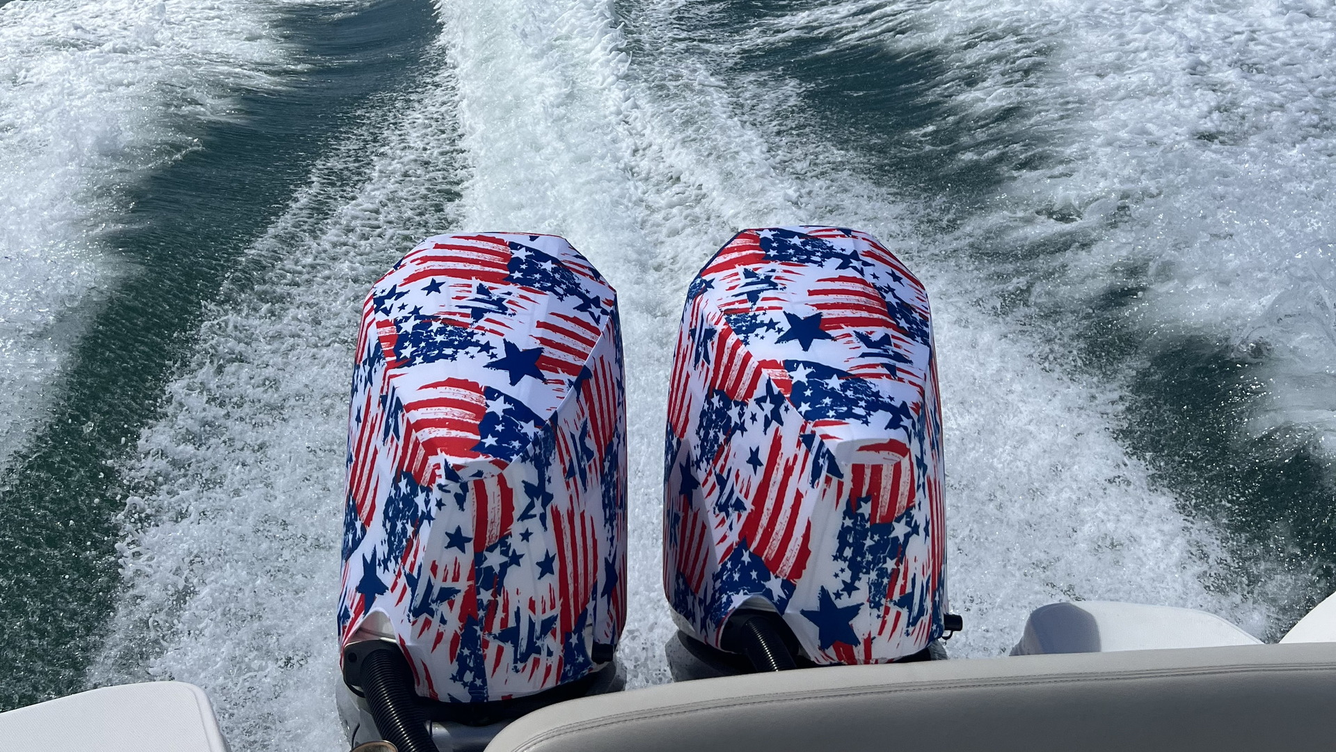 Outer Envy American Patriot vented outboard motor covers on twin outboards running at speed, wake behind the boat